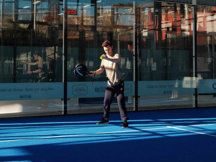 Cancha de pádel de un club con un jugador al fondo